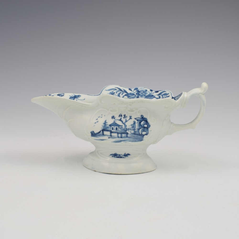 An 18th-century First Period Worcester soft-paste porcelain sauce boat decorated with a hand-painted blue and white chinoiserie landscape motif. View V
