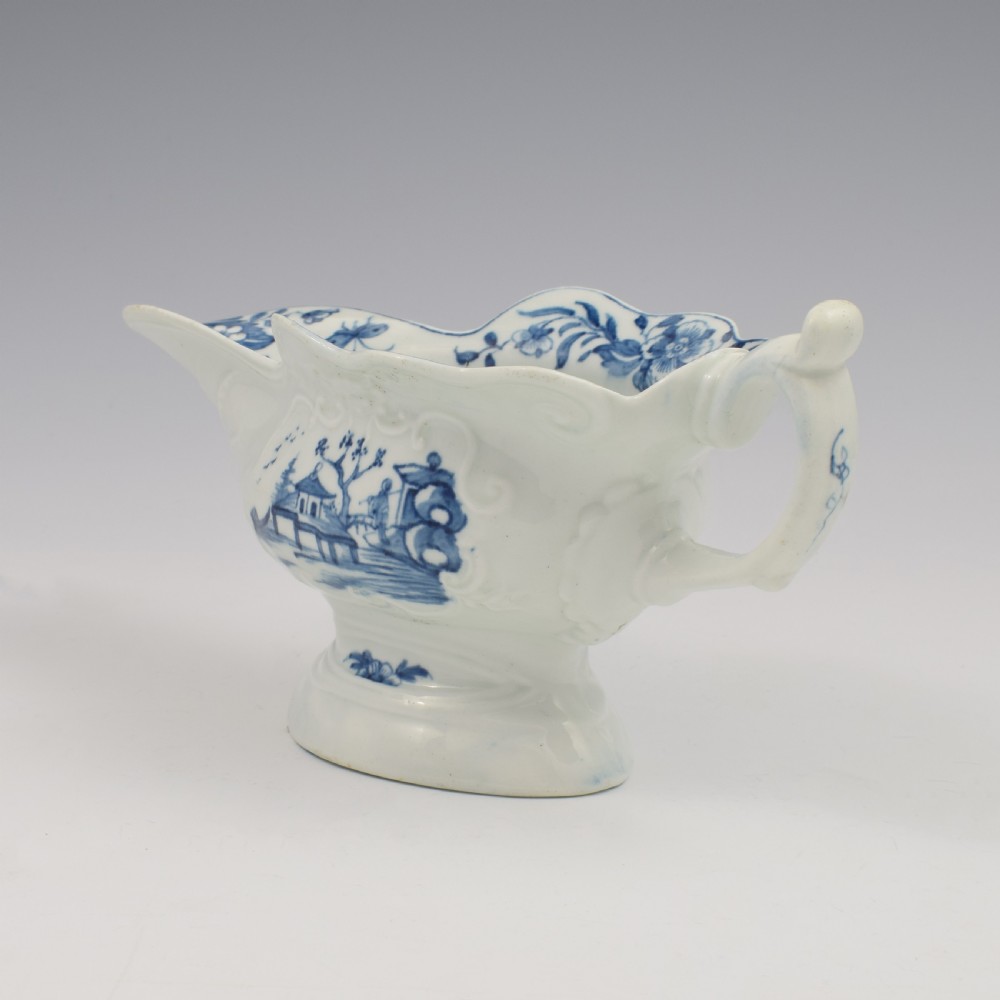 An 18th-century First Period Worcester soft-paste porcelain sauce boat decorated with a hand-painted blue and white chinoiserie landscape motif. View VI