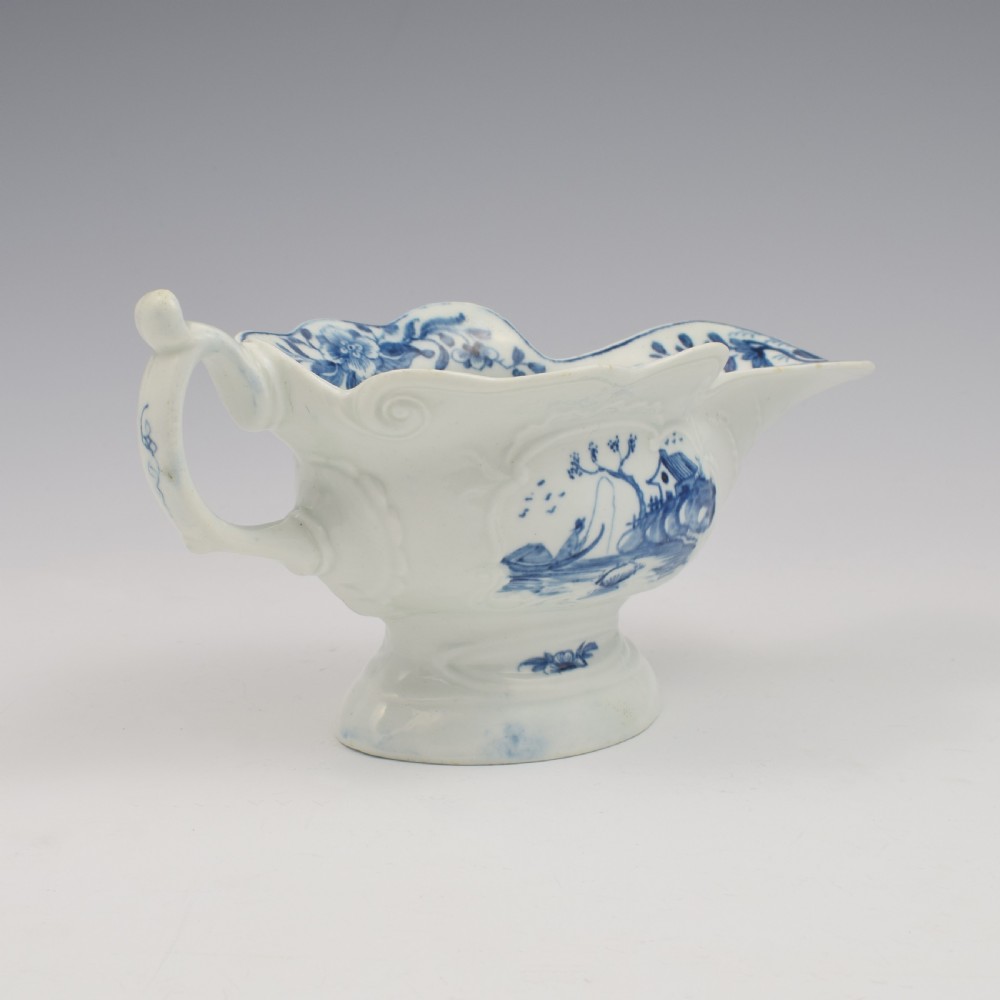 An 18th-century First Period Worcester soft-paste porcelain sauce boat decorated with a hand-painted blue and white chinoiserie landscape motif. View VIII