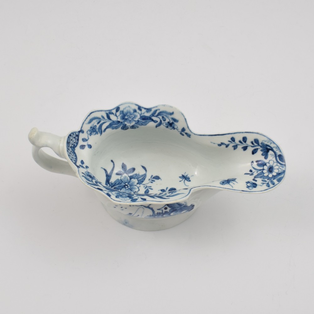An 18th-century First Period Worcester soft-paste porcelain sauce boat decorated with a hand-painted blue and white chinoiserie landscape motif. View XIII