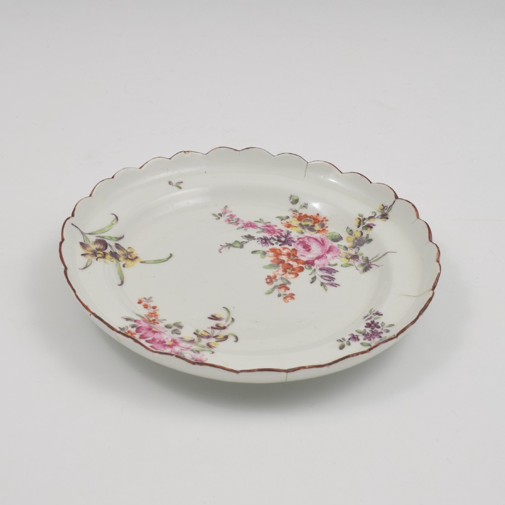 An 18th-century English soft-paste porcelain lobed plate decorated with hand-painted polychrome floral sprays and a brown line rim. View VII