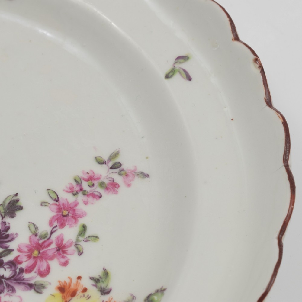 An 18th-century English soft-paste porcelain lobed plate decorated with hand-painted polychrome floral sprays and a brown line rim. View VIII