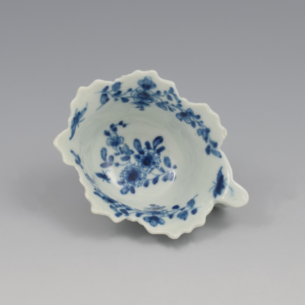 A leaf-shaped soft-paste porcelain butter boat decorated with an underglaze blue floral pattern and serrated edges. View II
