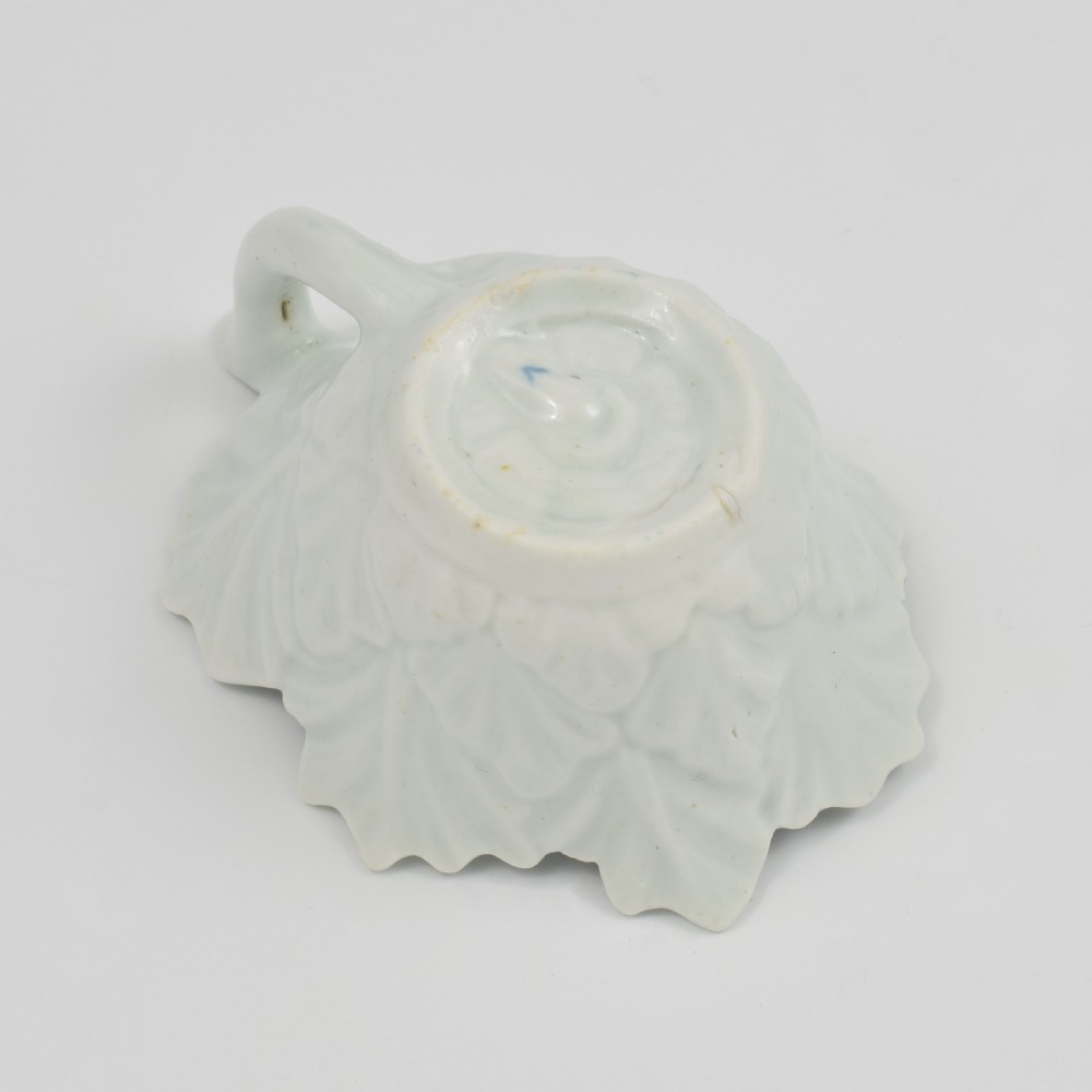 A leaf-shaped soft-paste porcelain butter boat decorated with an underglaze blue floral pattern and serrated edges. View IX