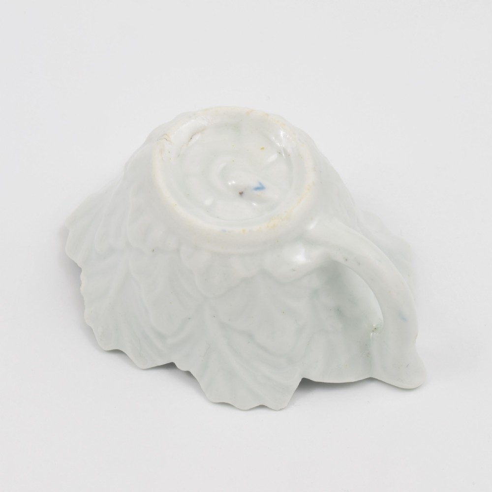 A leaf-shaped soft-paste porcelain butter boat decorated with an underglaze blue floral pattern and serrated edges. View X