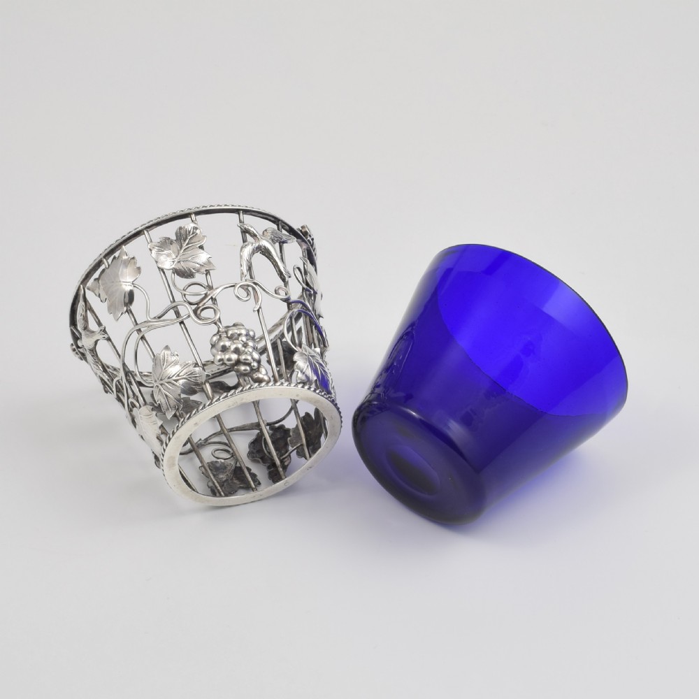 A Georgian sterling silver wirework cream pail featuring botanical motifs and a twisted overhead handle, fitted with a cobalt blue glass liner. View XIII