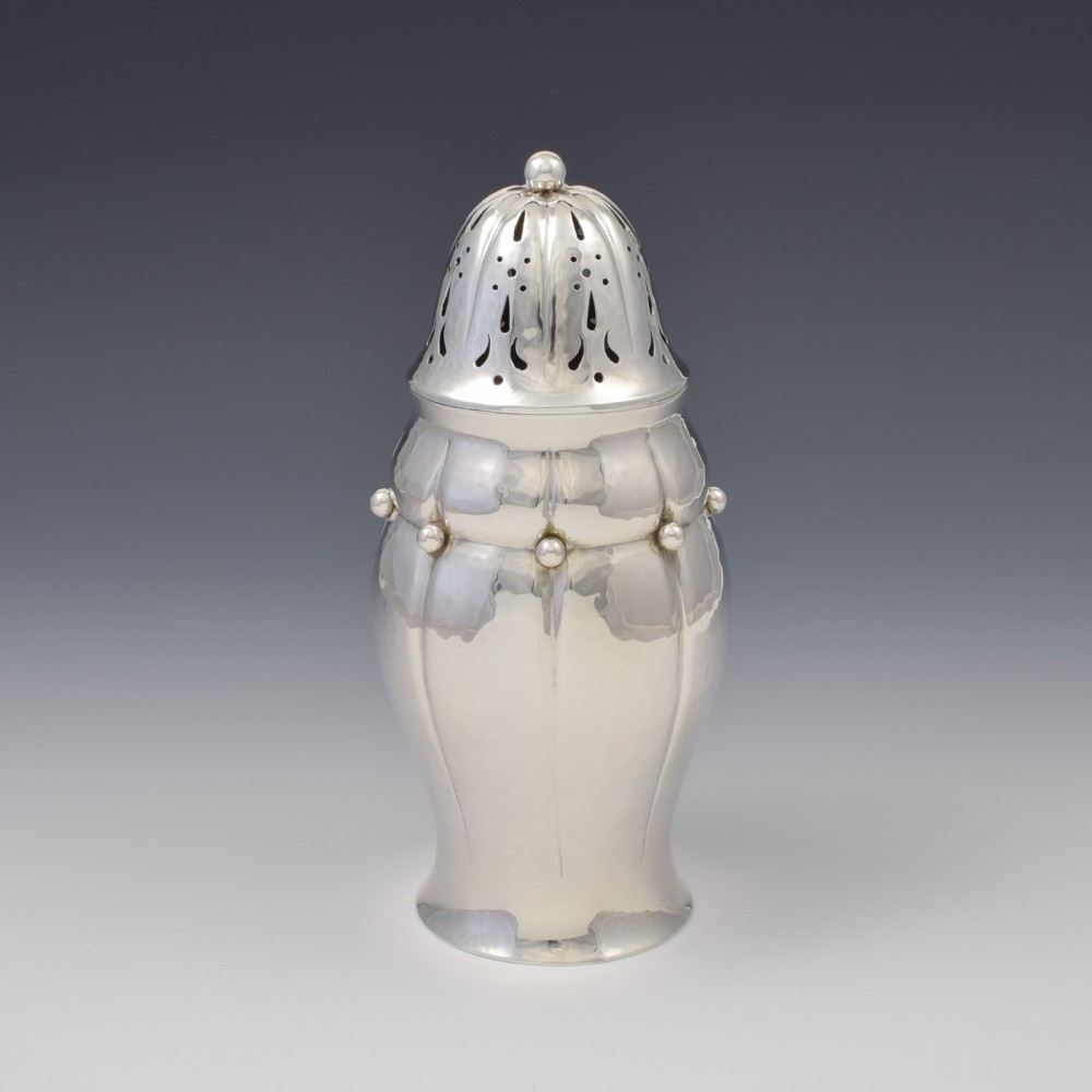 An Art Nouveau Danish sterling silver sugar caster featuring a lobed body with applied bead details and a hand-pierced domed cover.