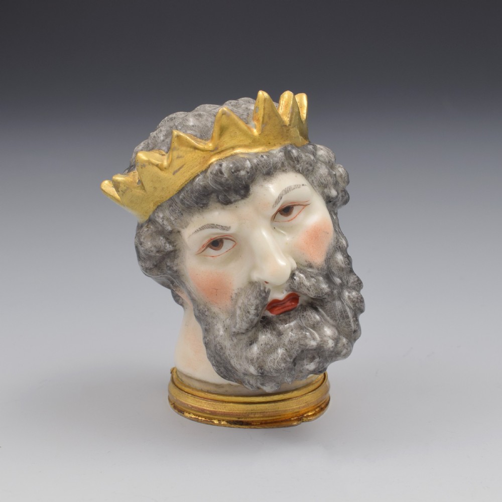 A French porcelain bonbonniere crafted in the shape of the bearded god Neptune with a gilt crown and mounted on a brass rim base. View II