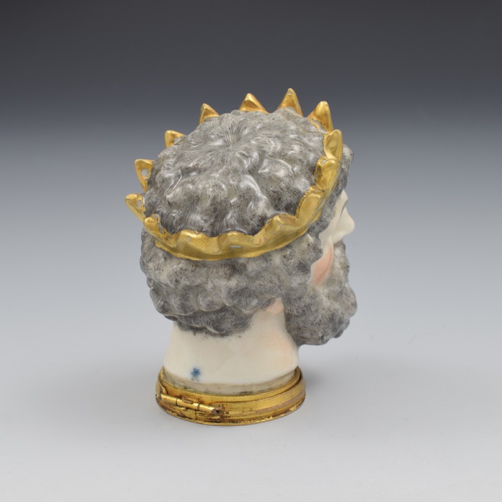 A French porcelain bonbonniere crafted in the shape of the bearded god Neptune with a gilt crown and mounted on a brass rim base. View IV