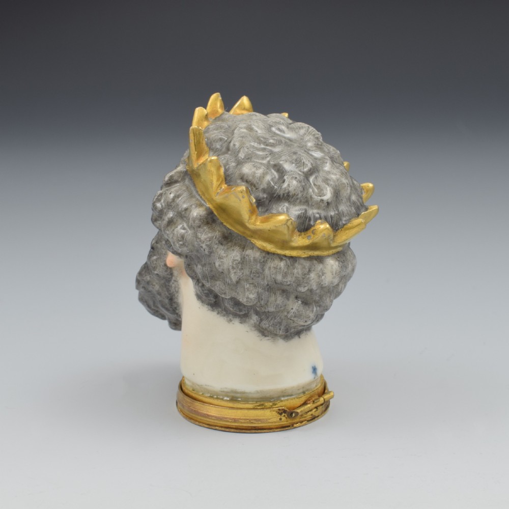 A French porcelain bonbonniere crafted in the shape of the bearded god Neptune with a gilt crown and mounted on a brass rim base. View VI
