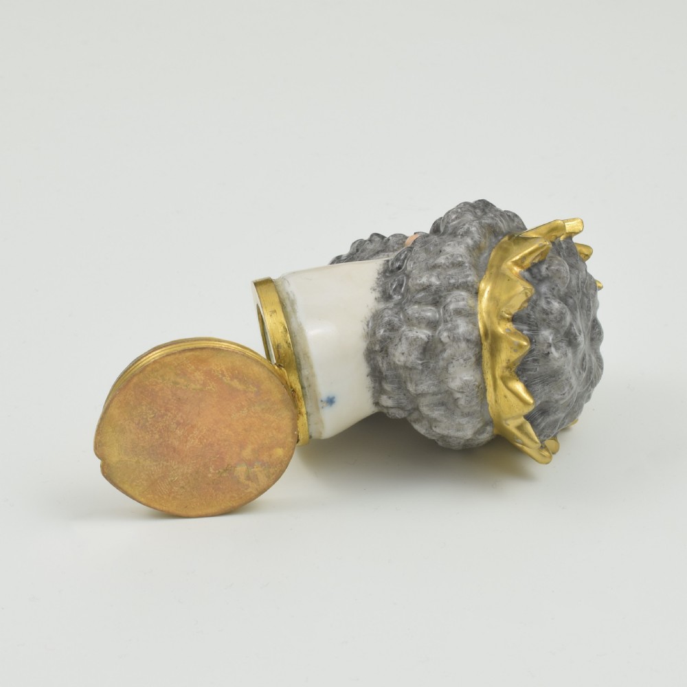 A French porcelain bonbonniere crafted in the shape of the bearded god Neptune with a gilt crown and mounted on a brass rim base. View XI