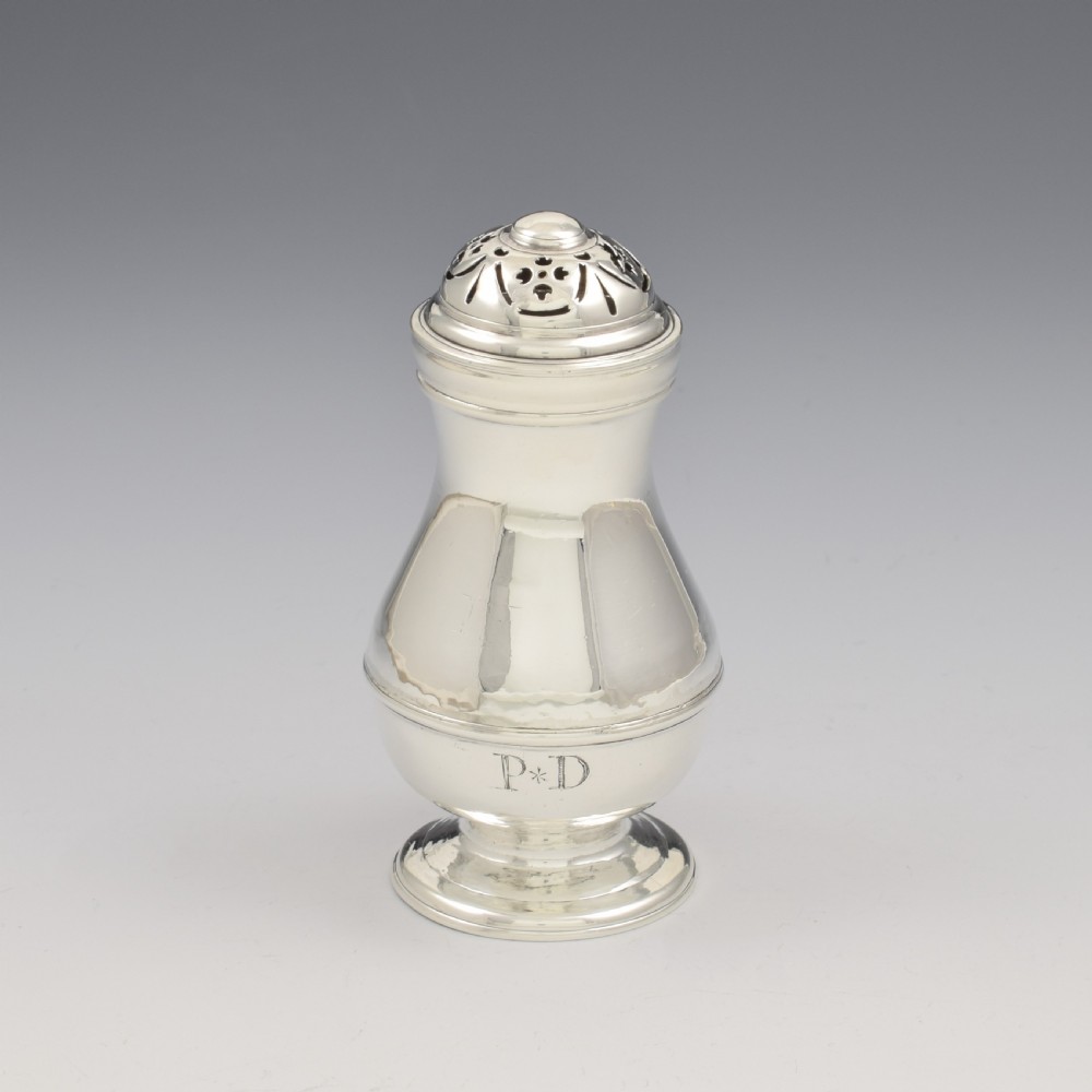 A George I sterling silver pounce pot with a faceted baluster body, stepped pedestal base, pierced dome cover, and engraved initials.