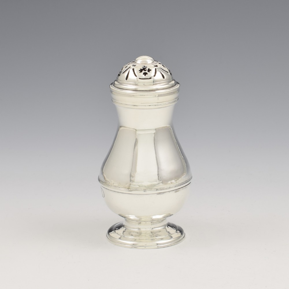 A George I sterling silver pounce pot with a faceted baluster body, stepped pedestal base, pierced dome cover, and engraved initials. View IV