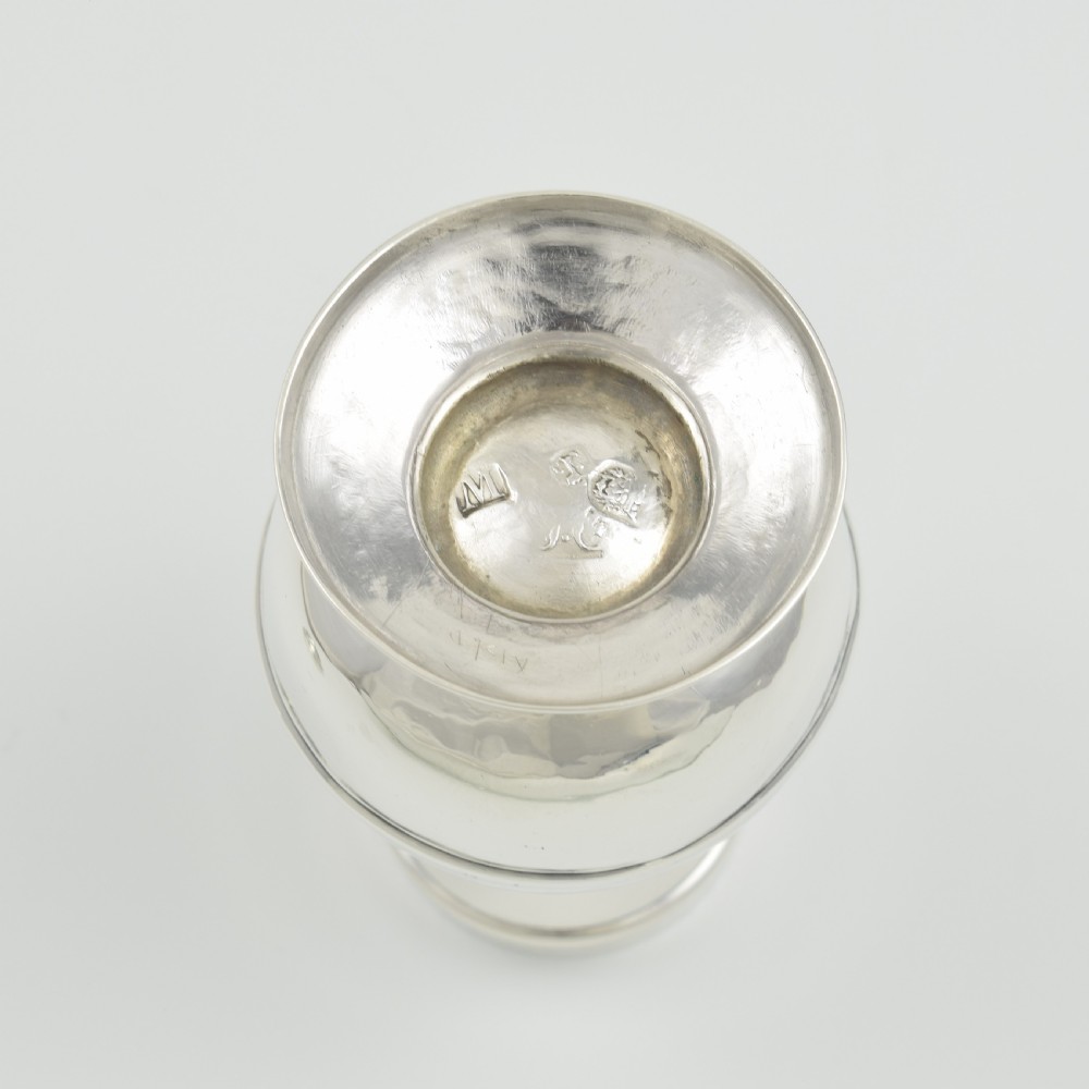 A George I sterling silver pounce pot with a faceted baluster body, stepped pedestal base, pierced dome cover, and engraved initials. View IX