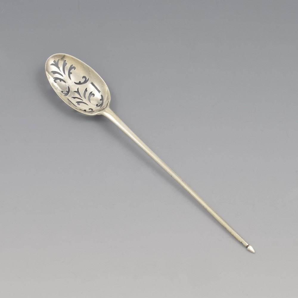 A George II sterling silver mote spoon featuring a pierced oval bowl with scrollwork fretwork and a long tapered spike stem. View II