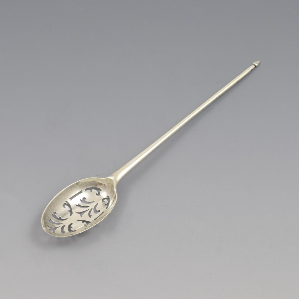 A George II sterling silver mote spoon featuring a pierced oval bowl with scrollwork fretwork and a long tapered spike stem. View III