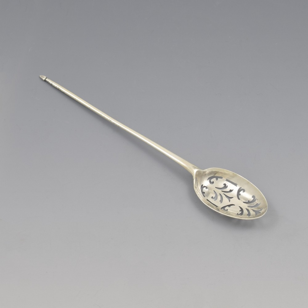 A George II sterling silver mote spoon featuring a pierced oval bowl with scrollwork fretwork and a long tapered spike stem. View IV
