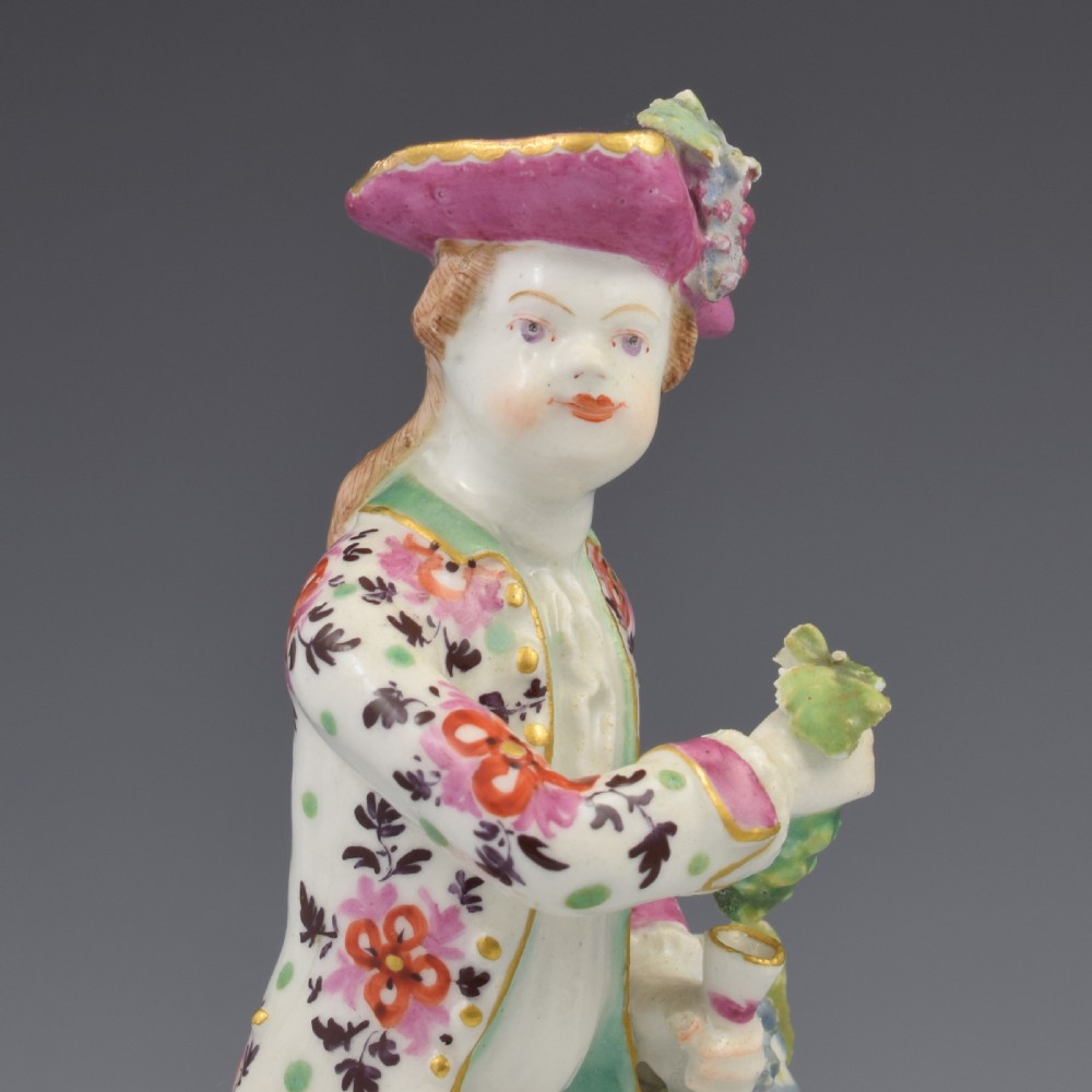 An 18th-century Bow soft-paste porcelain figure depicting an allegorical youth standing beside floral bocage on a pierced gilded scroll base. View XIII