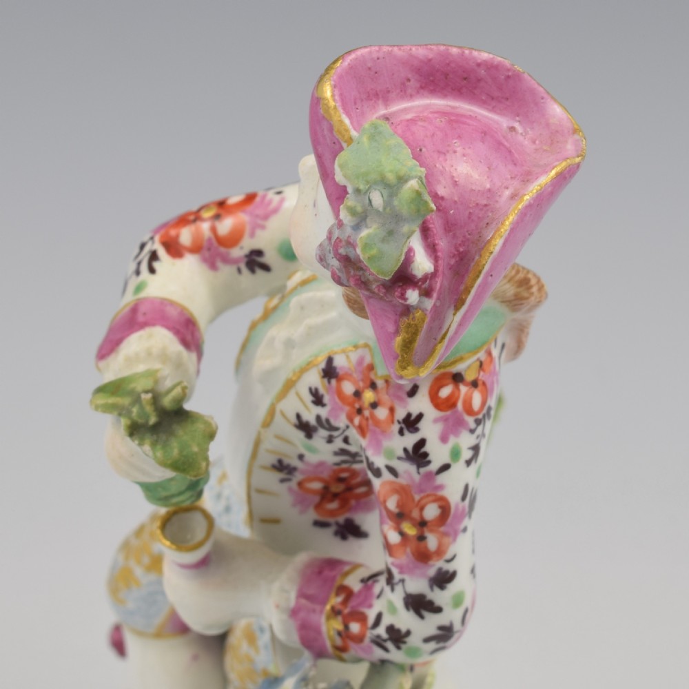 An 18th-century Bow soft-paste porcelain figure depicting an allegorical youth standing beside floral bocage on a pierced gilded scroll base. View XIV
