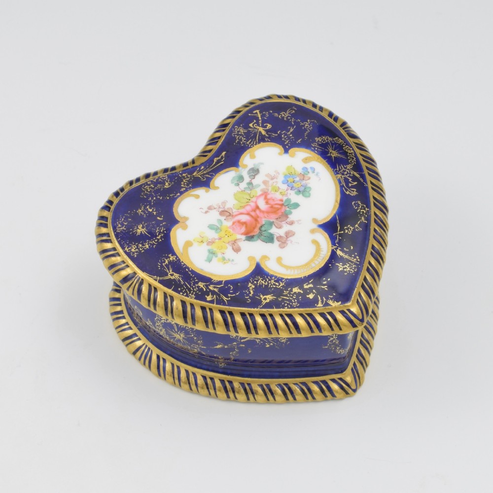 A heart-shaped cobalt blue porcelain jewellery box featuring a hand-painted floral cartouche and detailed gilding along ribbed edges. View II