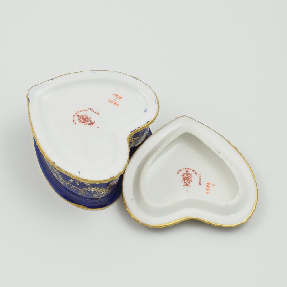 A heart-shaped cobalt blue porcelain jewellery box featuring a hand-painted floral cartouche and detailed gilding along ribbed edges. View XII