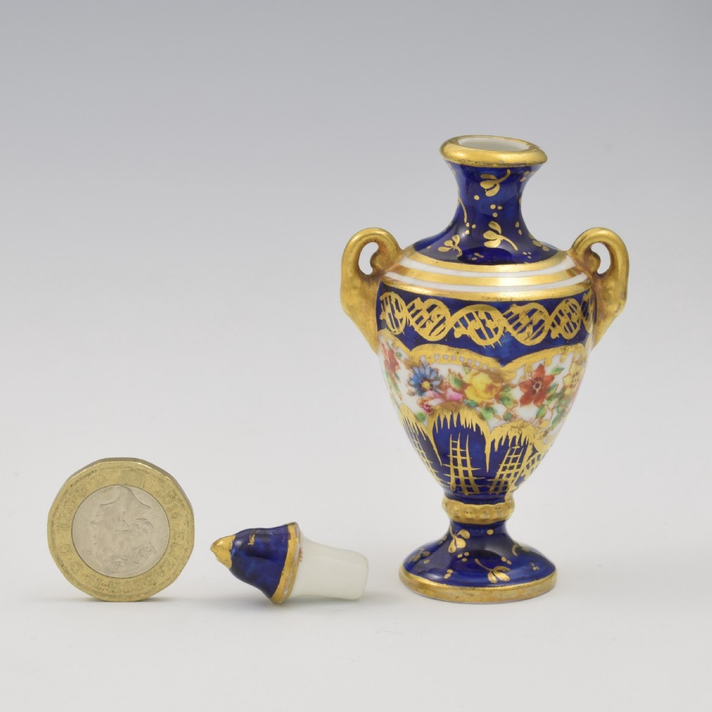 An Edwardian miniature cobalt blue porcelain scent bottle in urn form with twin gilt handles and hand-painted floral panels. View VI
