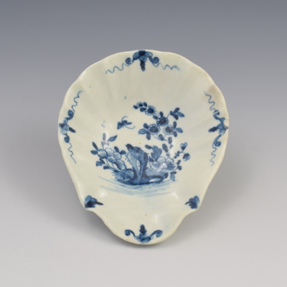 A shell-moulded 18th-century blue and white Worcester porcelain pickle dish featuring hand-painted floral and bird motifs.