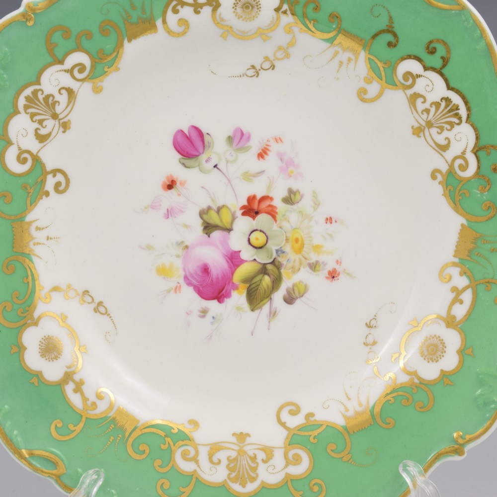 A Regency Minton porcelain dessert plate featuring a scalloped rim, broad apple green border with gilded scrolls, and a hand-painted floral bouquet at the centre. View II