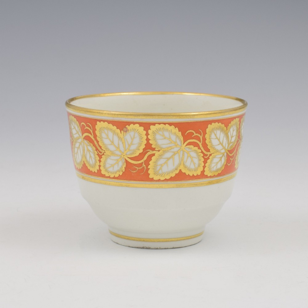 An early 19th-century Worcester porcelain tea cup and saucer featuring an orange border decorated with gilded leaf motifs on a white ground. View IV