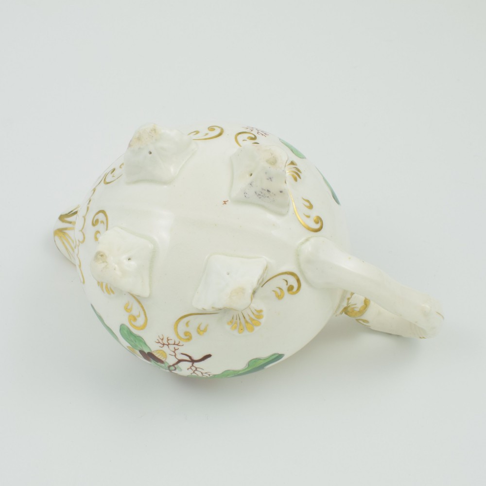 A cream-coloured Regency porcelain jug featuring hand-painted green oak leaves, brown acorns, moulded feet, and gilded trim. View XI