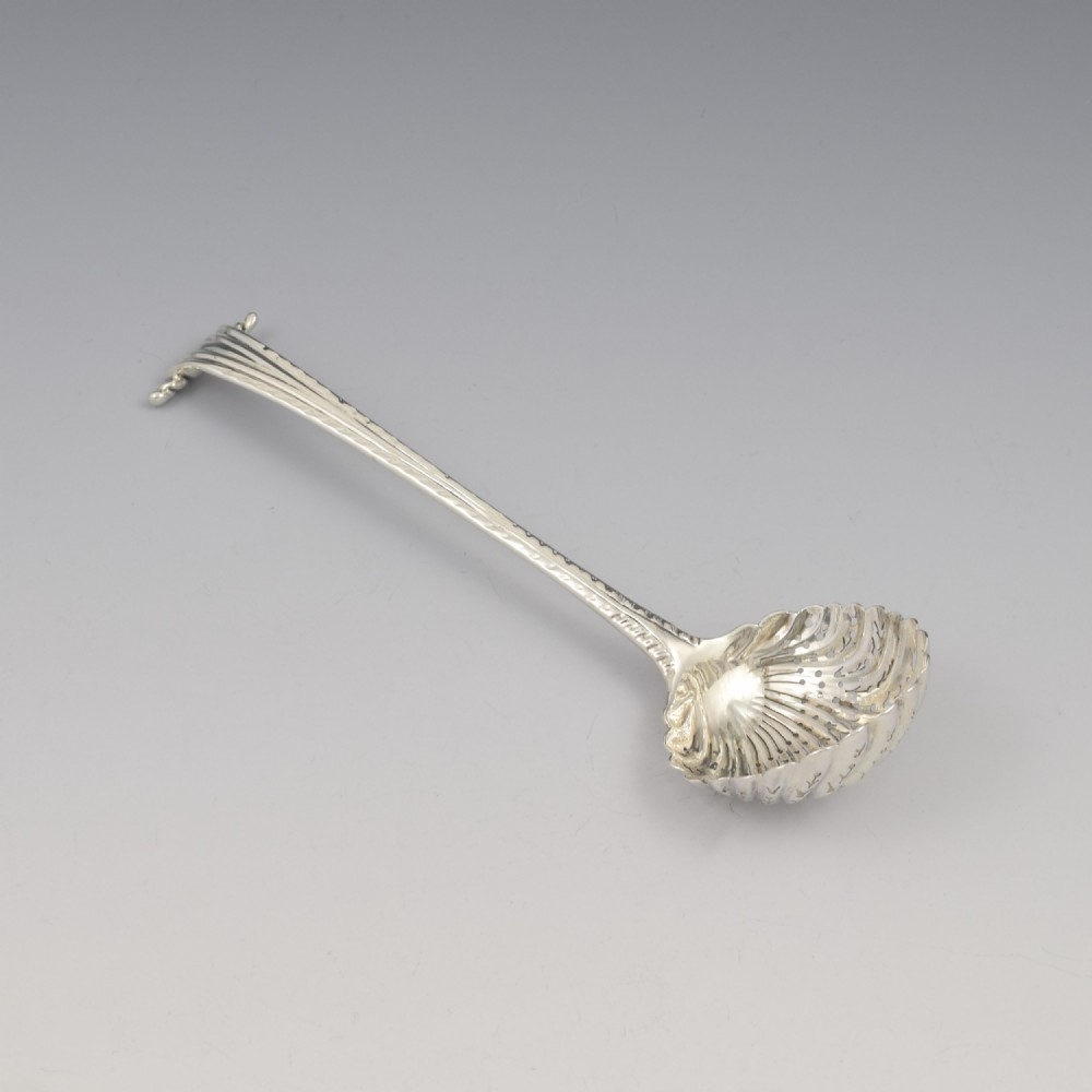 An 18th-century sterling silver sifter spoon featuring an Onslow scroll terminal, feather-edge shaft, and a pierced shell bowl. View III