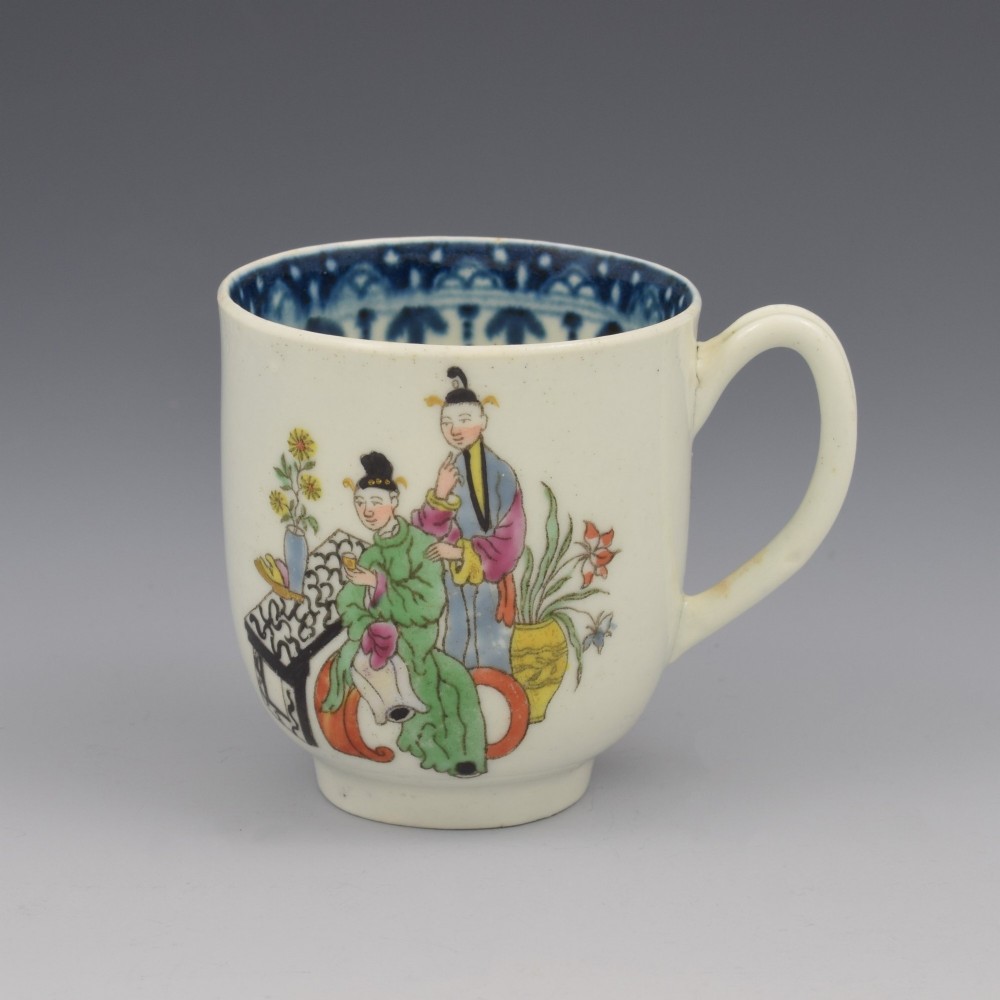 An 18th-century white porcelain coffee cup featuring a hand-painted polychrome figure scene in the Chinoiserie style with a blue patterned inner border.