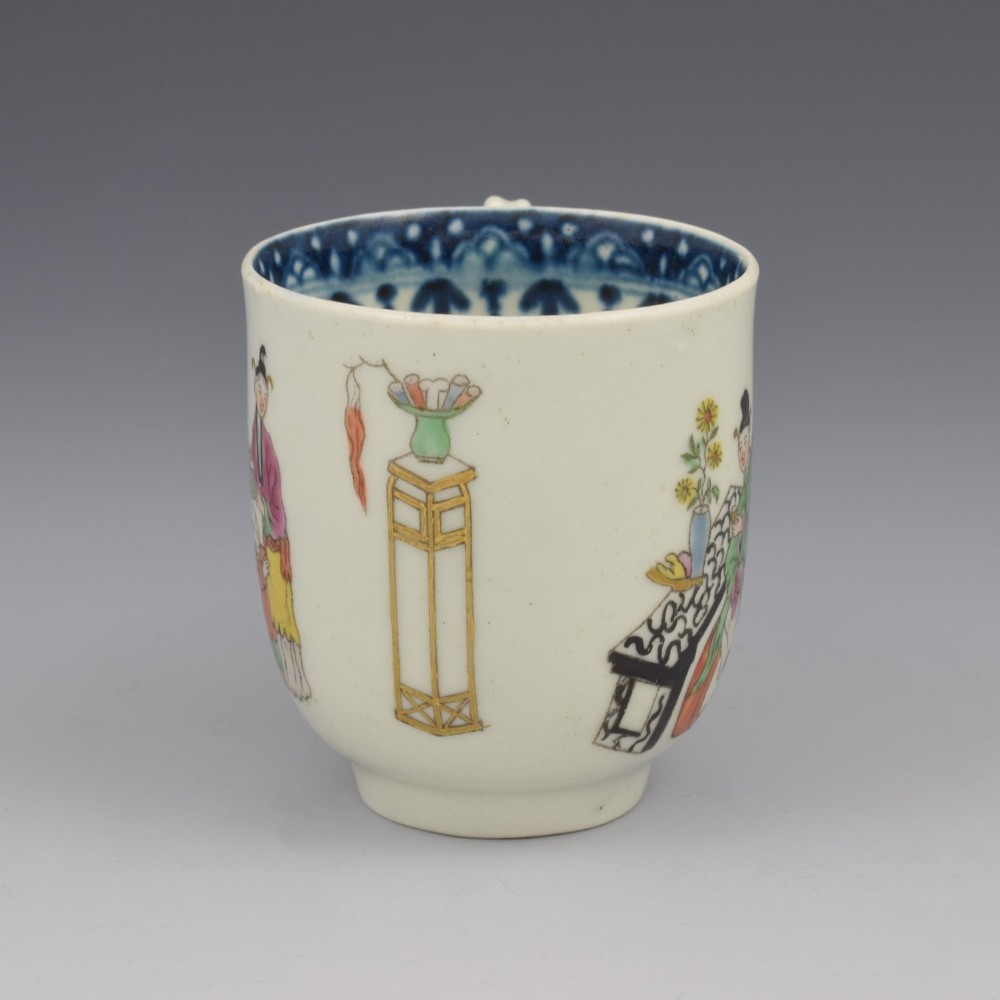 An 18th-century white porcelain coffee cup featuring a hand-painted polychrome figure scene in the Chinoiserie style with a blue patterned inner border. View II