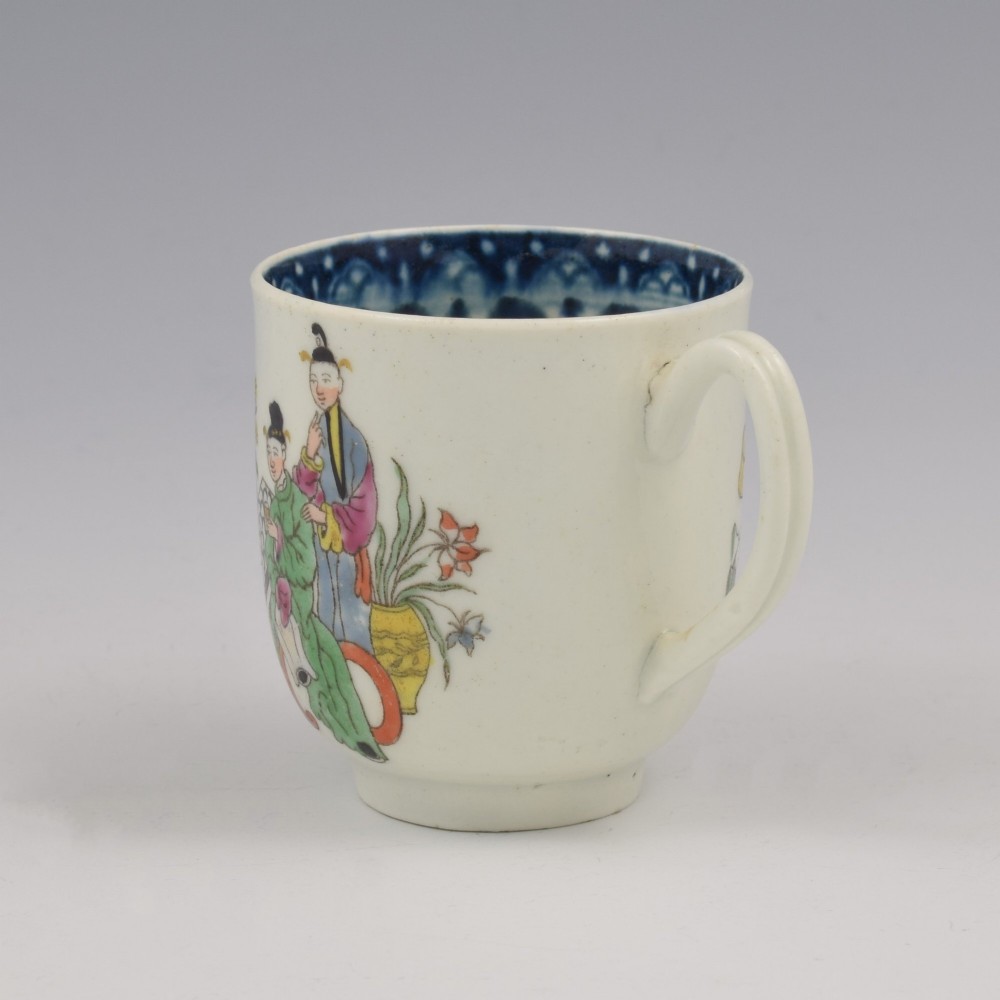 An 18th-century white porcelain coffee cup featuring a hand-painted polychrome figure scene in the Chinoiserie style with a blue patterned inner border. View VI