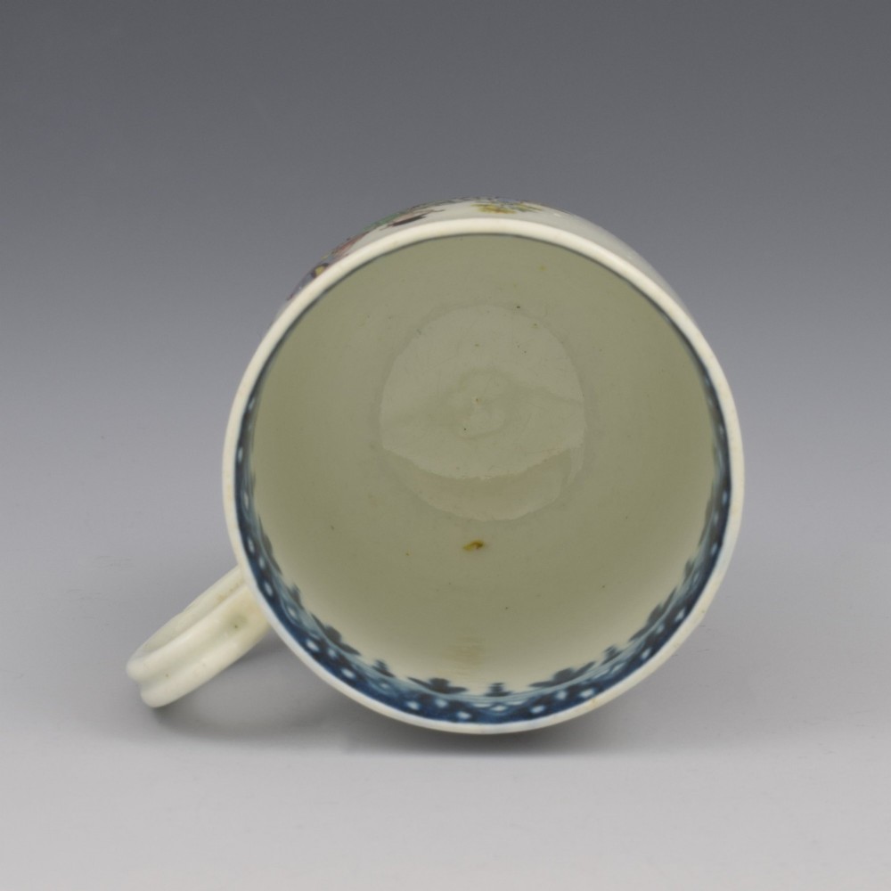 An 18th-century white porcelain coffee cup featuring a hand-painted polychrome figure scene in the Chinoiserie style with a blue patterned inner border. View VII