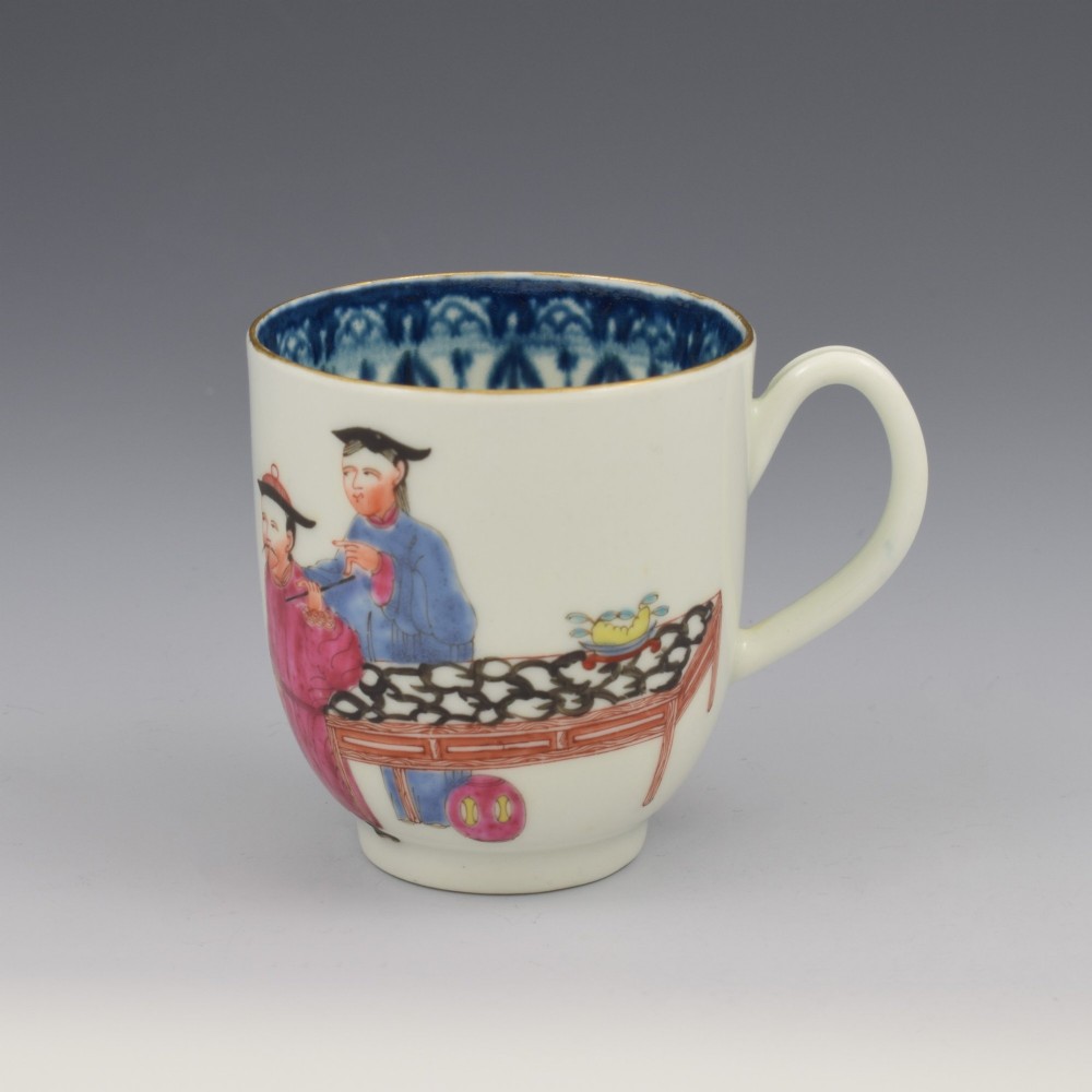 An 18th-century white porcelain coffee cup decorated with hand-painted Chinese figures in red and blue enamel, featuring a single handle and an internal patterned rim. View IV