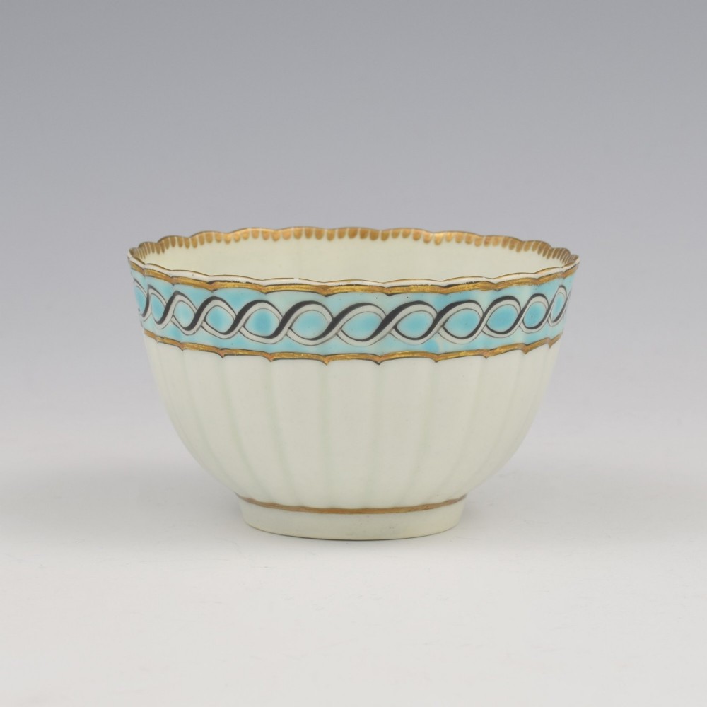 An eighteenth-century Worcester soft-paste porcelain fluted tea bowl and saucer featuring a turquoise and black guilloche border with gilded rim details. View V