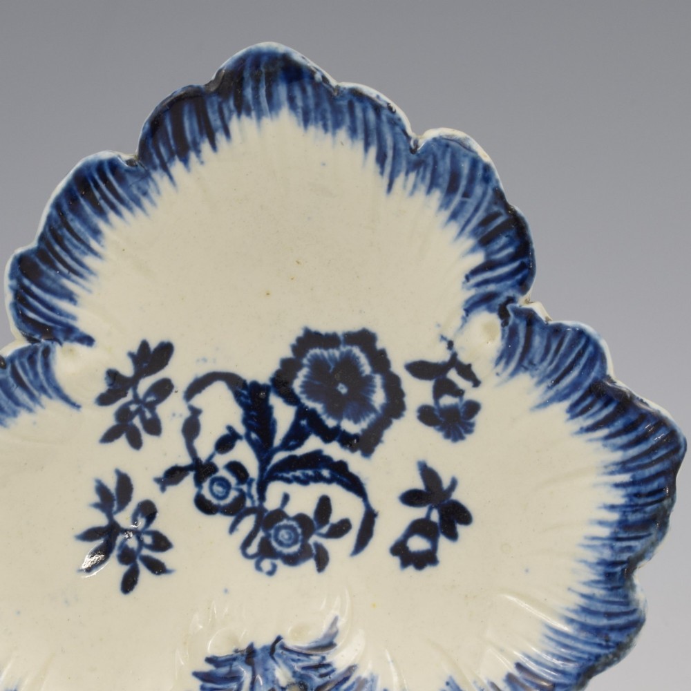 A leaf-shaped Georgian soft-paste porcelain pickle dish decorated with hand-painted underglaze blue floral motifs and a feathered edge. View II
