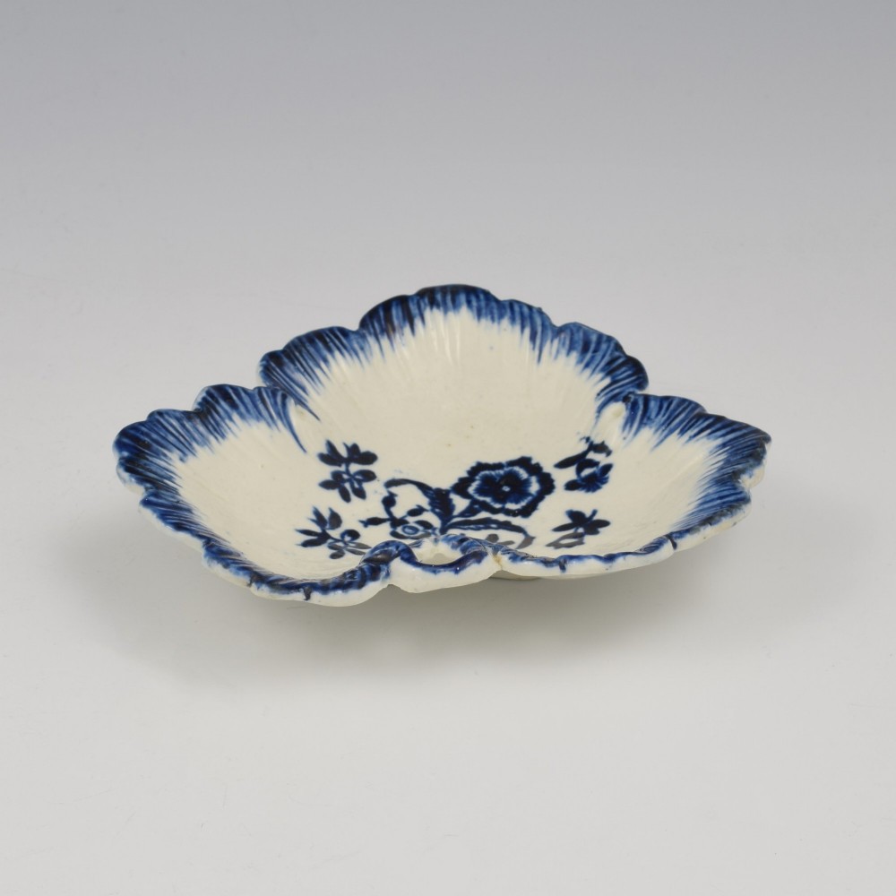 A leaf-shaped Georgian soft-paste porcelain pickle dish decorated with hand-painted underglaze blue floral motifs and a feathered edge. View IV