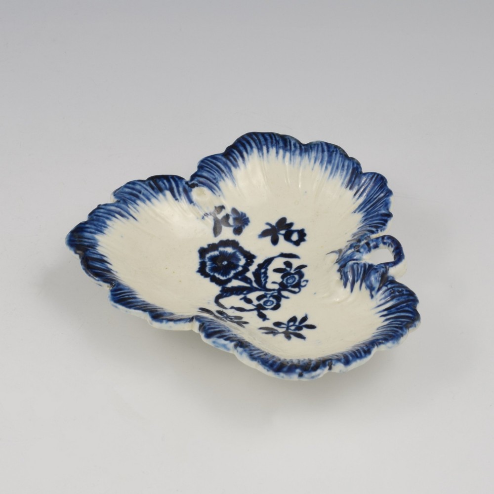 A leaf-shaped Georgian soft-paste porcelain pickle dish decorated with hand-painted underglaze blue floral motifs and a feathered edge. View V