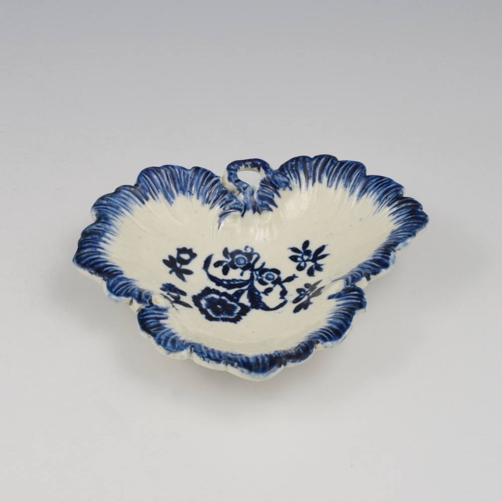 A leaf-shaped Georgian soft-paste porcelain pickle dish decorated with hand-painted underglaze blue floral motifs and a feathered edge. View VI