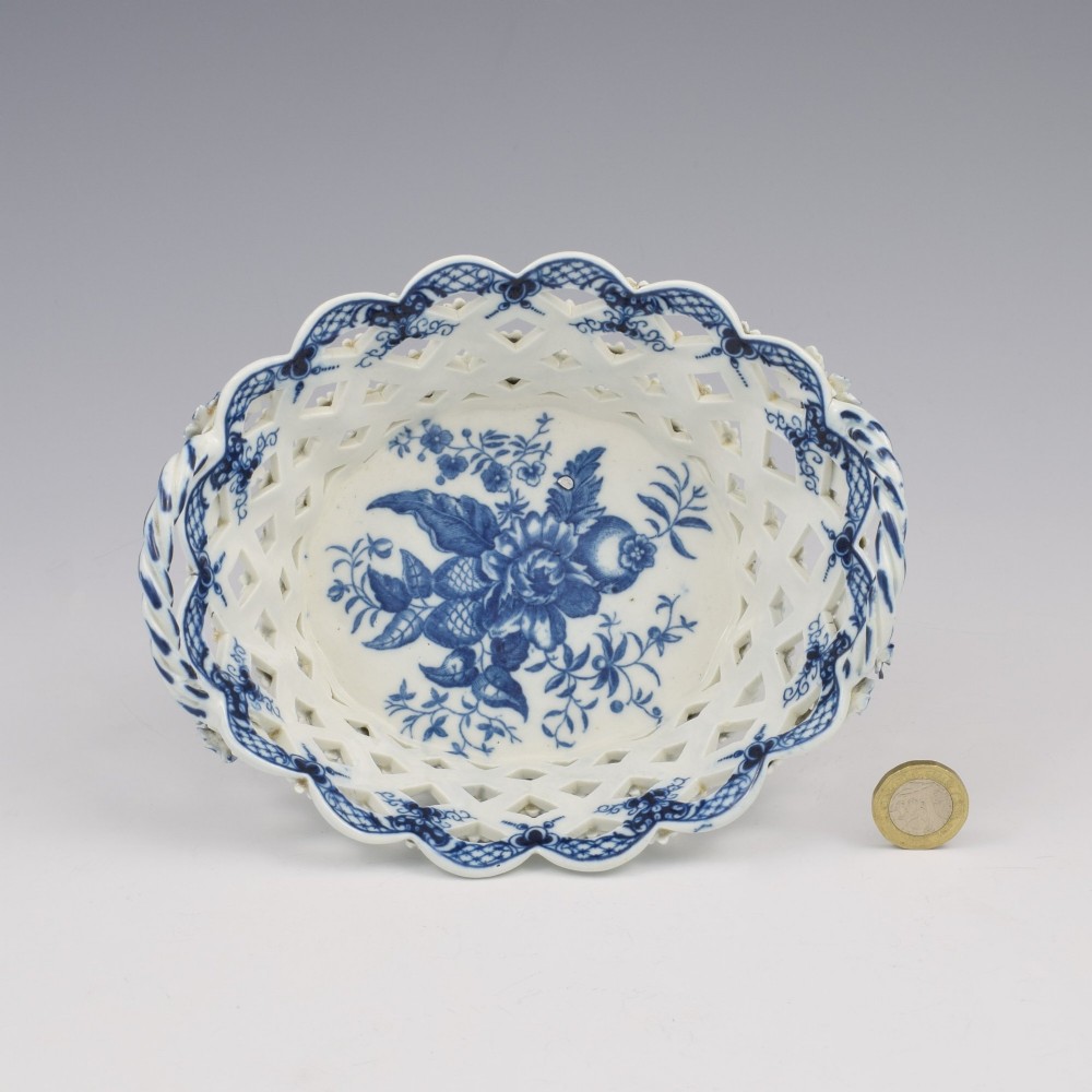 An 18th-century oval blue and white soft-paste porcelain basket with reticulated lattice sides, twisted rope handles, and an underglaze floral pine cone pattern. View III