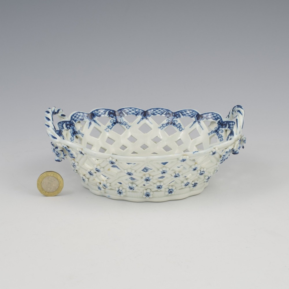 An 18th-century oval blue and white soft-paste porcelain basket with reticulated lattice sides, twisted rope handles, and an underglaze floral pine cone pattern. View IV
