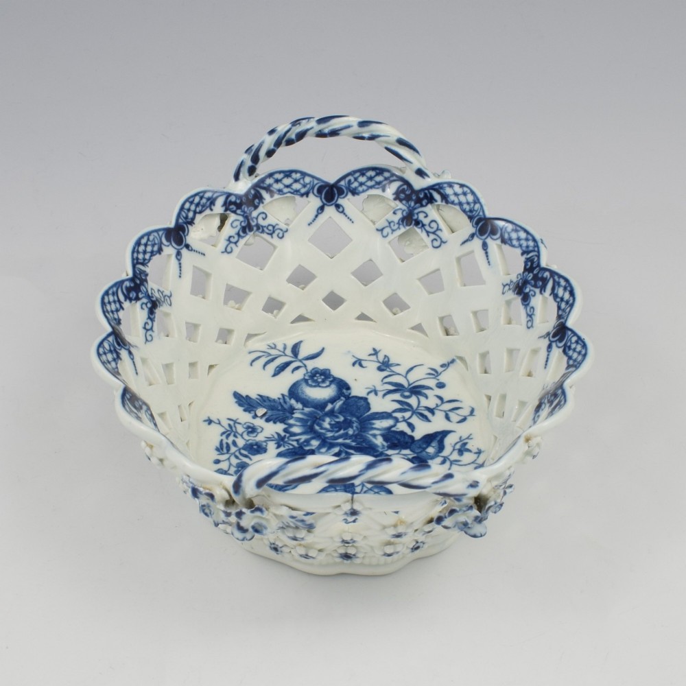 An 18th-century oval blue and white soft-paste porcelain basket with reticulated lattice sides, twisted rope handles, and an underglaze floral pine cone pattern. View VII