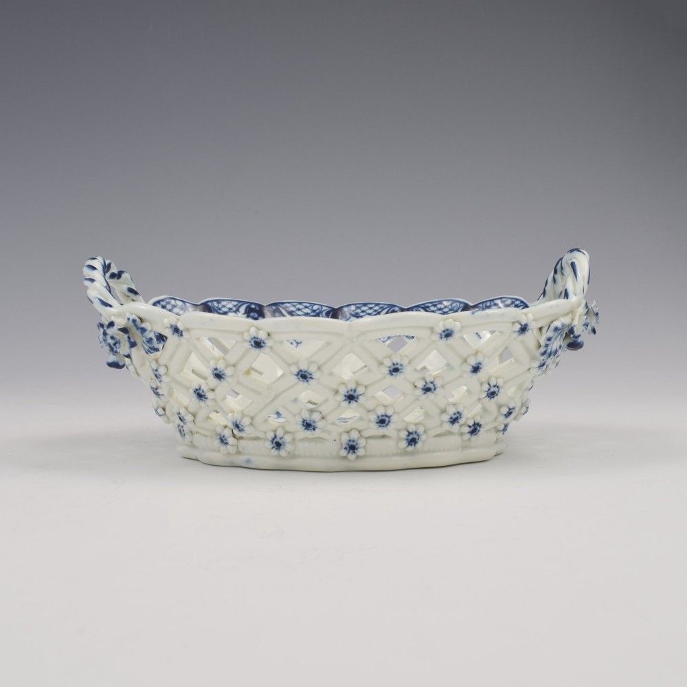 An 18th-century oval blue and white soft-paste porcelain basket with reticulated lattice sides, twisted rope handles, and an underglaze floral pine cone pattern. View XII
