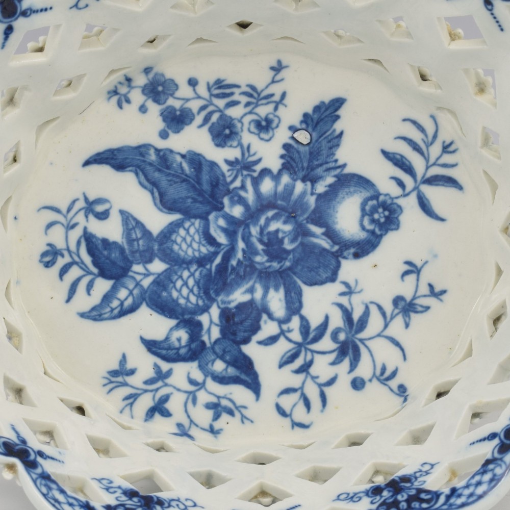 An 18th-century oval blue and white soft-paste porcelain basket with reticulated lattice sides, twisted rope handles, and an underglaze floral pine cone pattern. View XIV