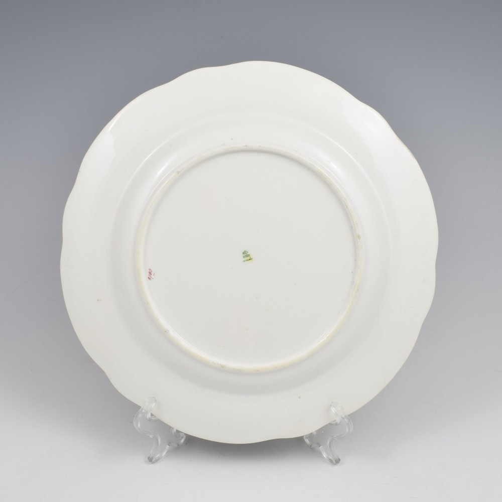 A 19th-century Copeland porcelain plate featuring a cobalt blue border with gilt scrollwork, hand-painted floral cartouches, and a central heraldic crest depicting a phoenix in flames above a coronet. View X
