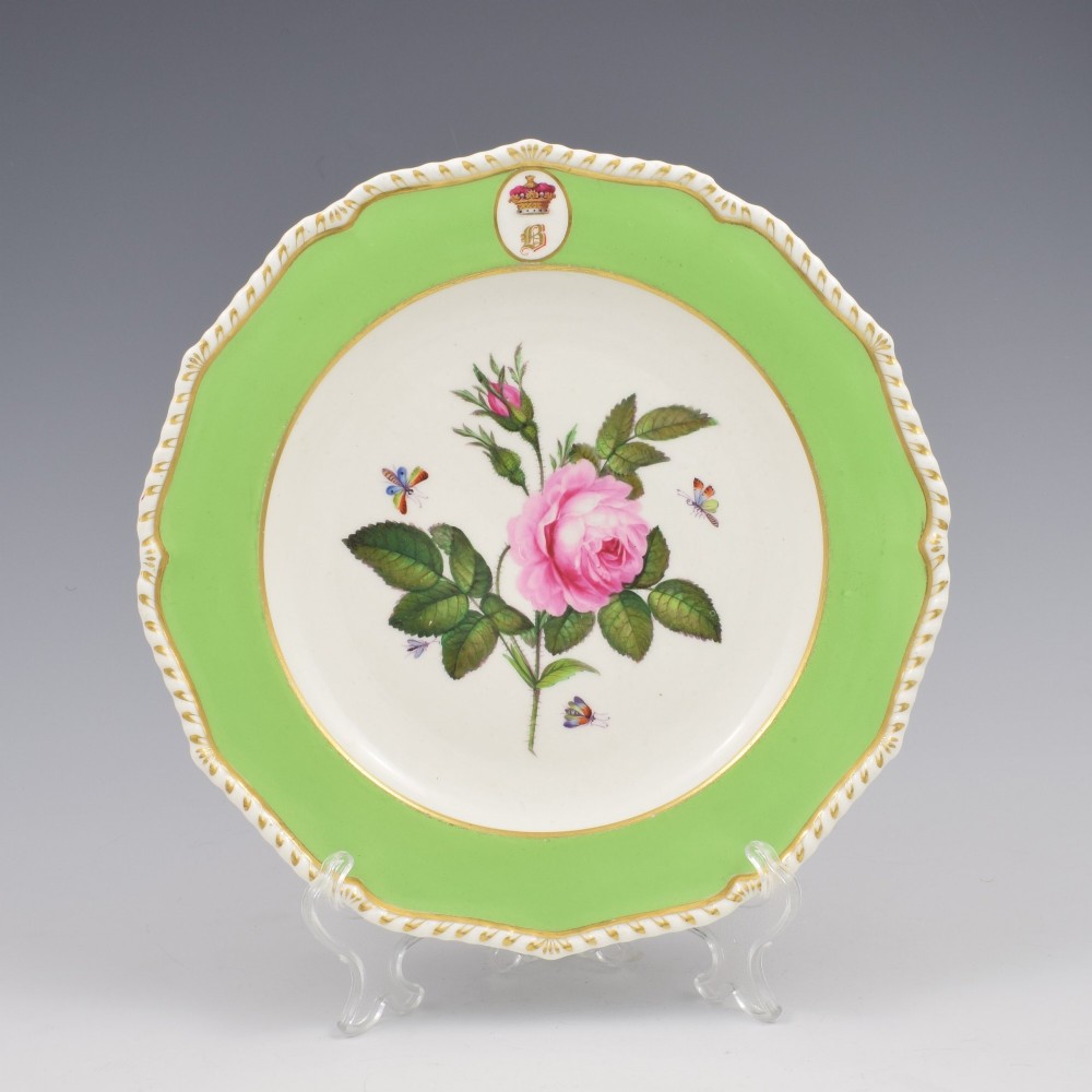 A Georgian Bloor Derby porcelain dessert plate with an apple green rim, a painted Marquess coronet crest, and a central hand-painted pink rose with insects.