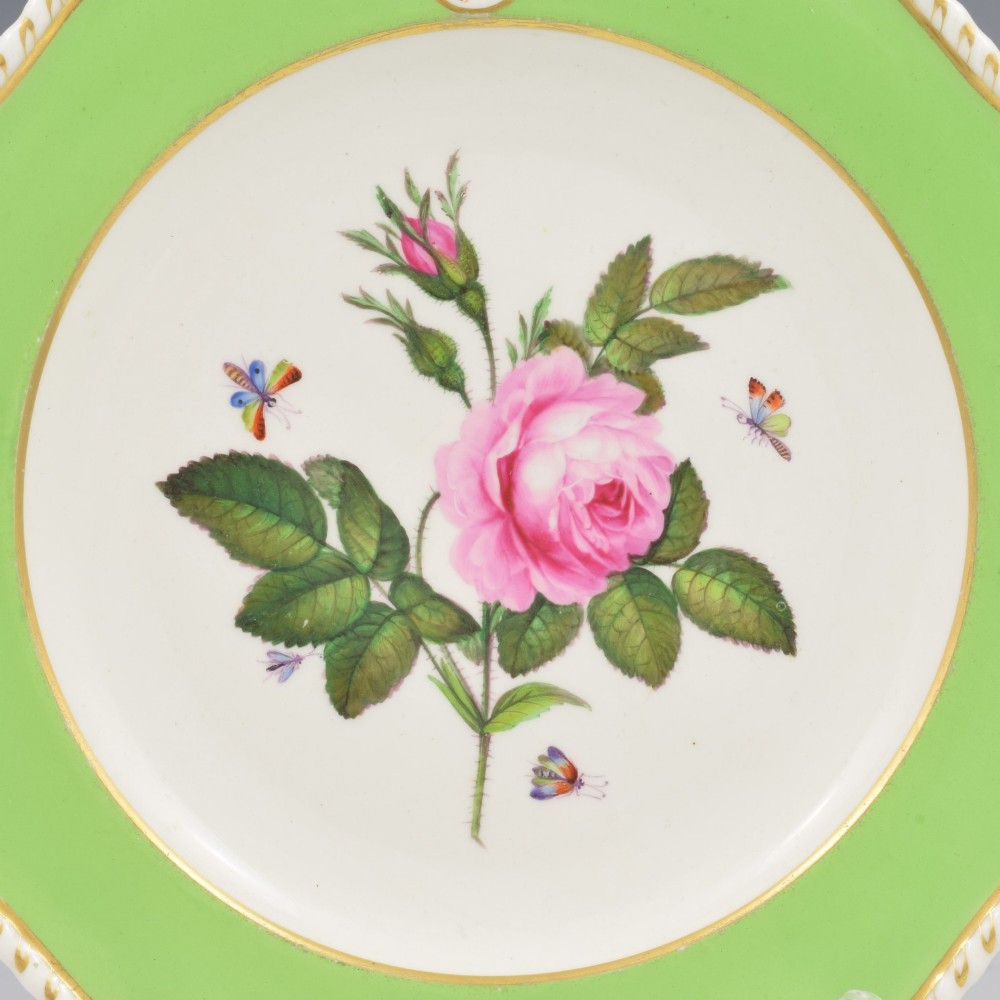 A Georgian Bloor Derby porcelain dessert plate with an apple green rim, a painted Marquess coronet crest, and a central hand-painted pink rose with insects. View II