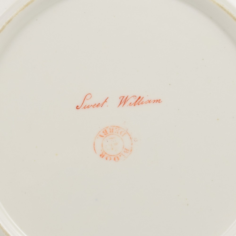 A Regency Bloor Derby porcelain plate featuring an apple green border with a marquess armorial crest, surrounding a central hand-painted illustration of pink Sweet William flowers and butterflies. View IX